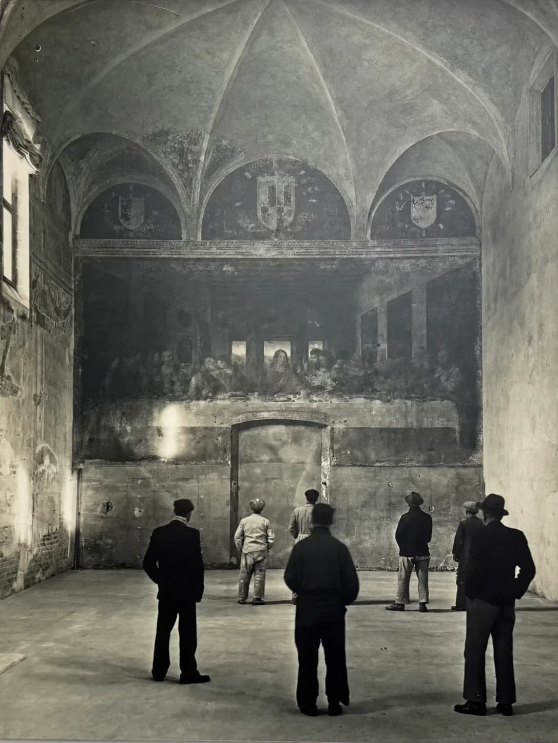 Historical monochrome image of visitors standing before The Last Supper